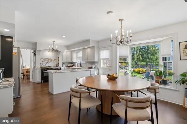 a open dining room with kitchen island furniture a chandelier and kitchen view