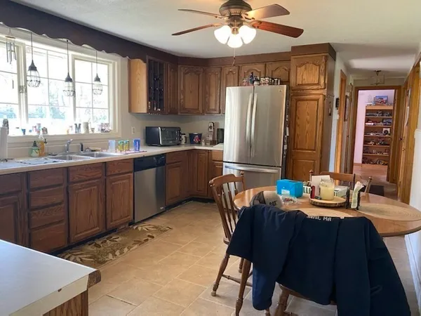 a kitchen with granite countertop a sink stainless steel appliances and windows