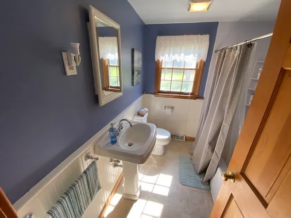 a bathroom with a sink mirror vanity and toilet