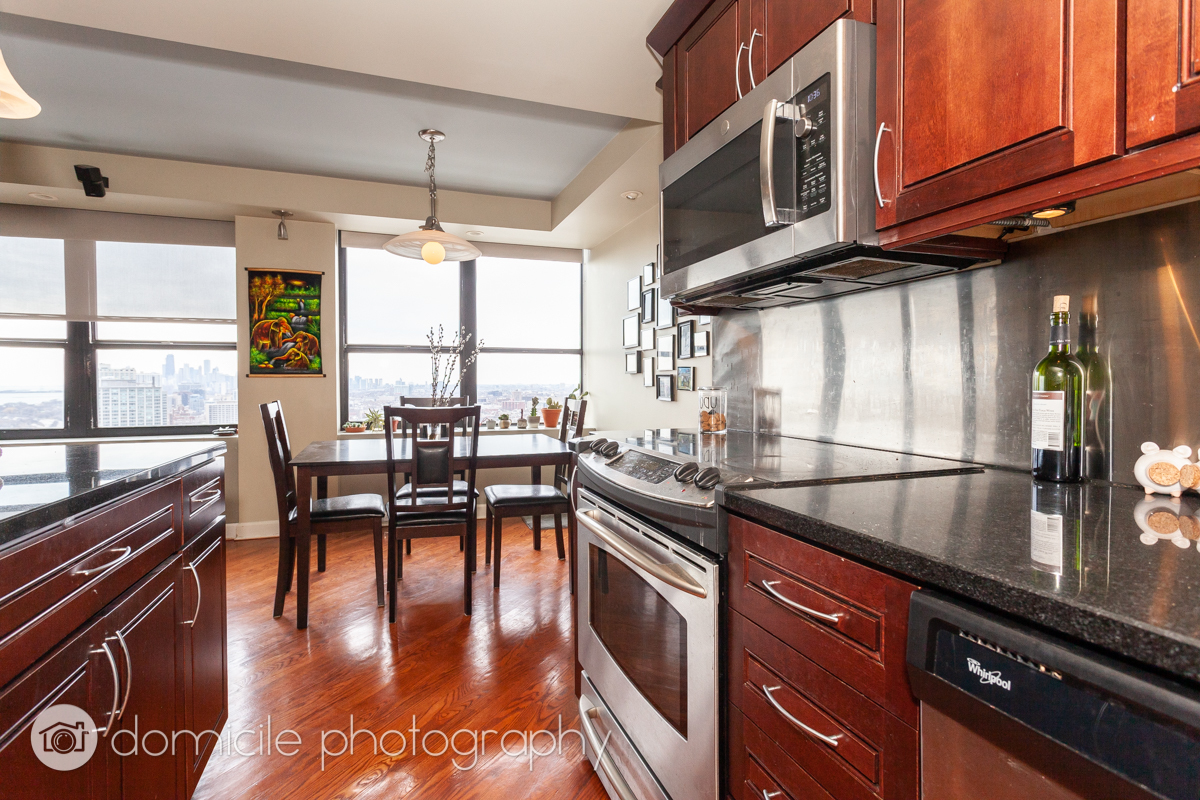 655 West Irving Park Road, Unit 3103 Chicago, IL 60613 - Photo 9 of 18 a kitchen with stainless steel appliances granite countertop a stove a sink and a microwave
