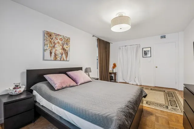 a bedroom with a bed and a painting on the wall