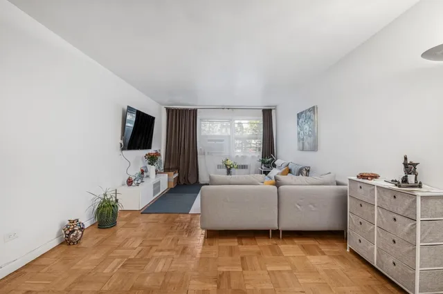 a living room with furniture a flat screen tv and a window