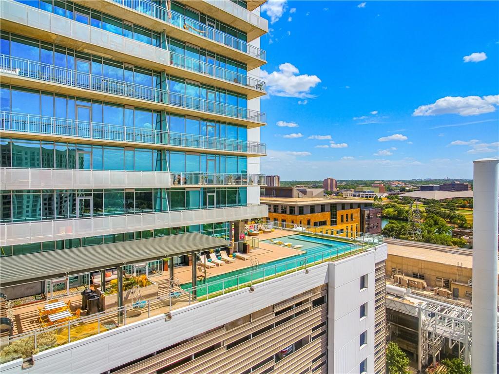 222 West Avenue, Unit 2207 Austin, TX 78701 - Photo 26 of 30 High-rise condominium building featuring expansive window walls, private balconies with metal railings, and a rooftop amenity deck with a swimming pool