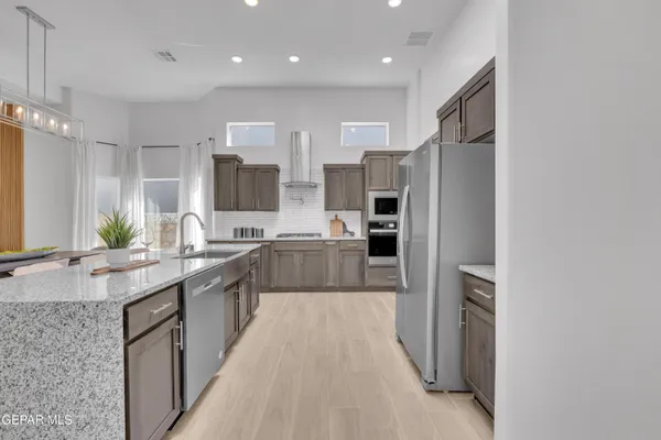 a large kitchen with stainless steel appliances lots of counter top space