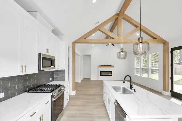 a kitchen with granite countertop a sink a stove and cabinets