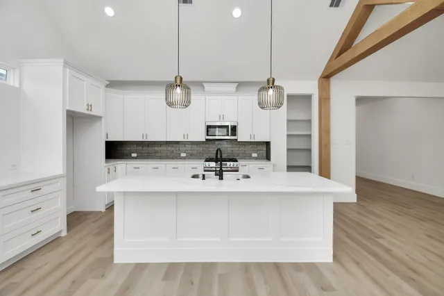 a kitchen with granite countertop a sink stainless steel appliances and cabinets