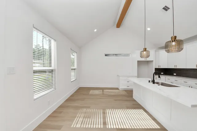a view of empty room with wooden floor and ceiling fan