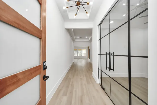 a view of a hallway with wooden floor and staircase