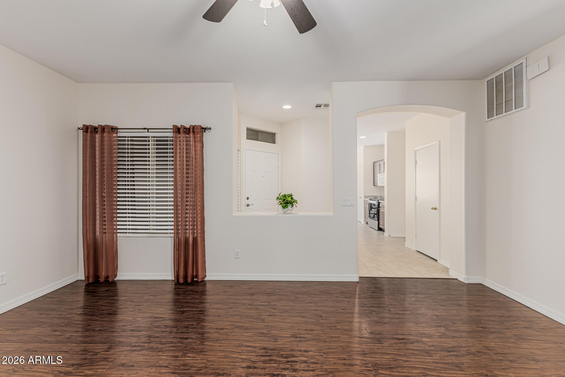 1650 South Crismon Road, Unit 16 Mesa, AZ 85209 - Photo 13 of 39 a view of an empty room with wooden floor and a window