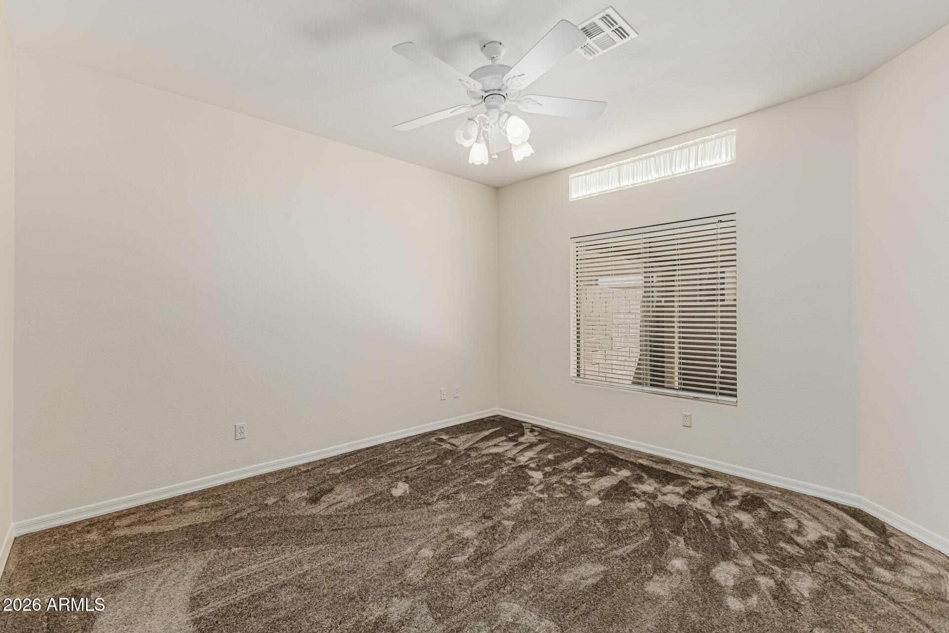 1650 South Crismon Road, Unit 16 Mesa, AZ 85209 - Photo 17 of 39 an empty room with chandelier fan and windows