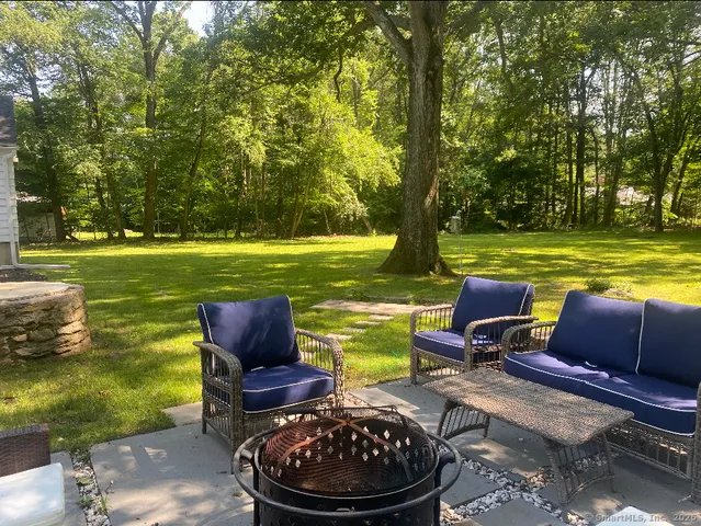 a view of a swimming pool and lounge chairs in back yard of the house