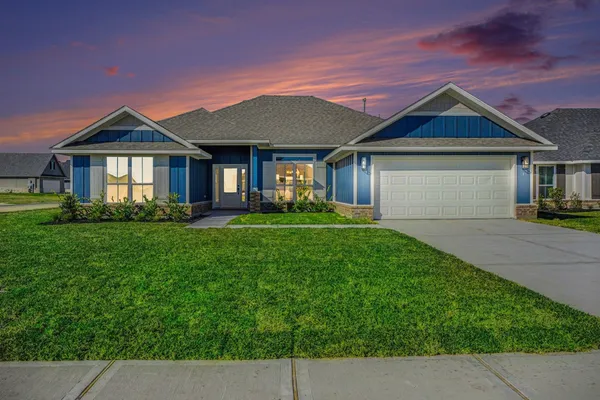 a front view of a house with a garden and plants