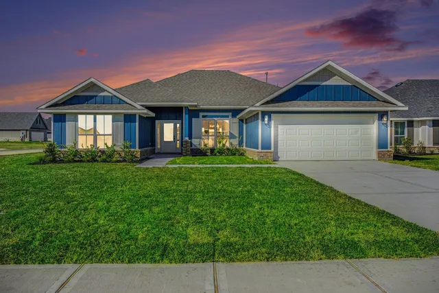 a front view of a house with a garden and plants