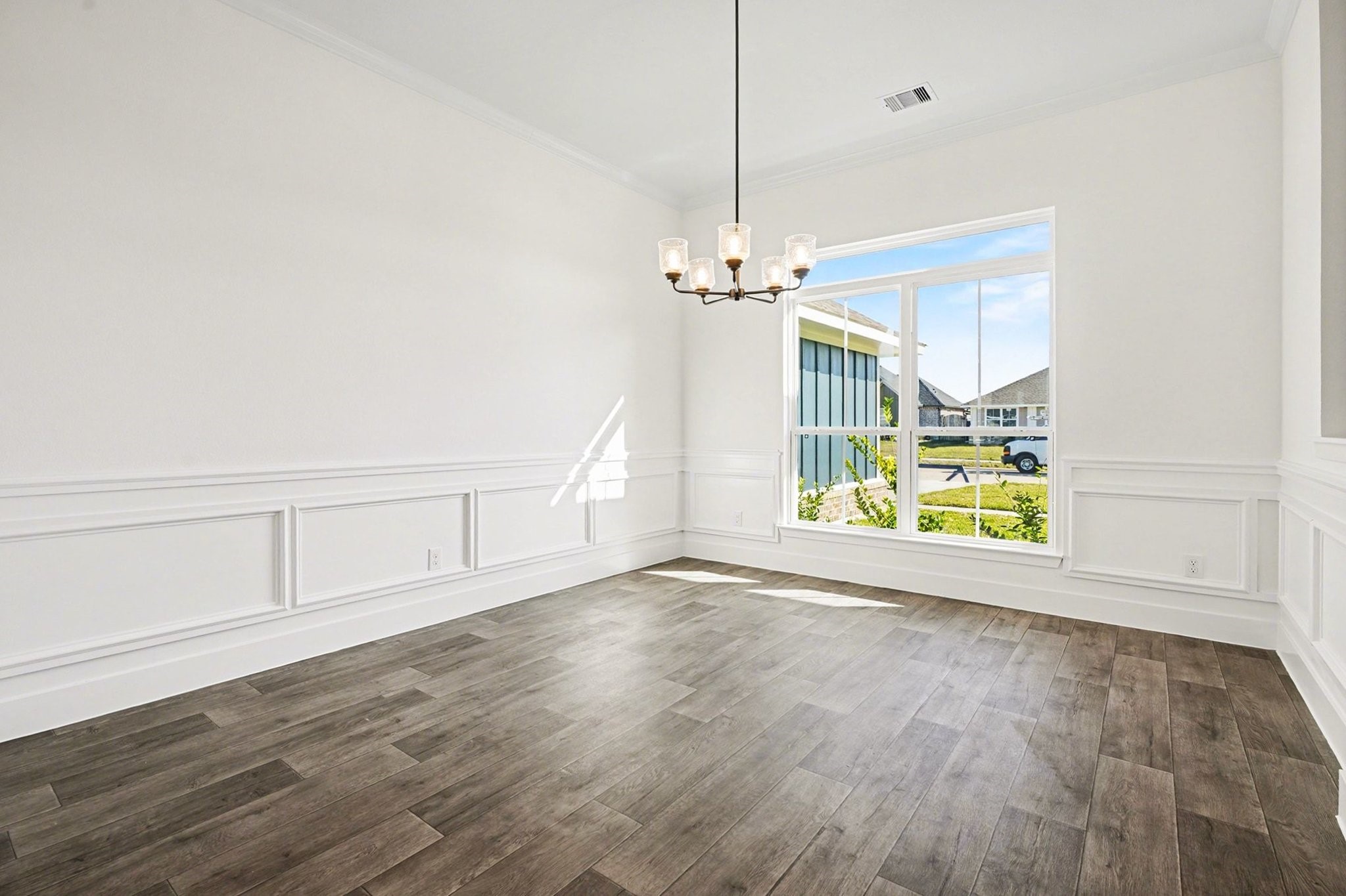 1 Keystone Court Angleton, TX 77515 - Photo 9 of 26 an empty room with wooden floor chandelier fan and windows