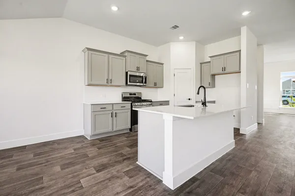 a kitchen with white cabinets and stainless steel appliances
