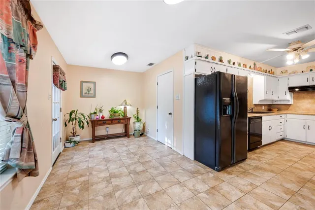 a kitchen with refrigerator and cabinets