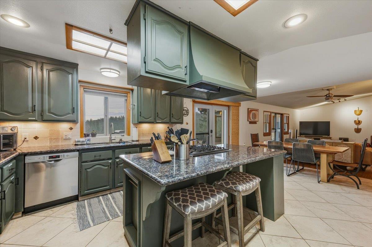 14752 Little Greenhorn Road Grass Valley, CA 95945 - Photo 11 of 35 a kitchen with stainless steel appliances granite countertop a table chairs sink and cabinets