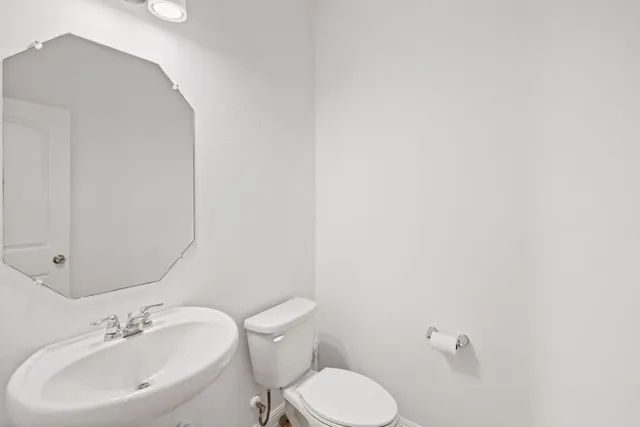 a bathroom with a sink mirror and toilet