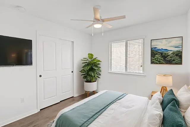 a bedroom with a bed and a potted plant