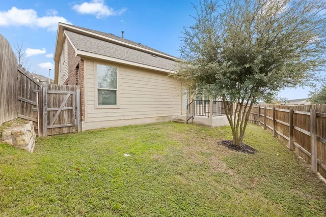 a view of backyard with wooden fence