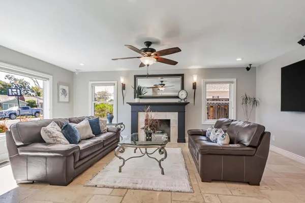 a living room with furniture a fireplace and a large window