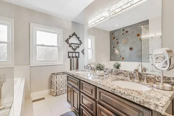 a bathroom with double vanity sinks a mirror and a window