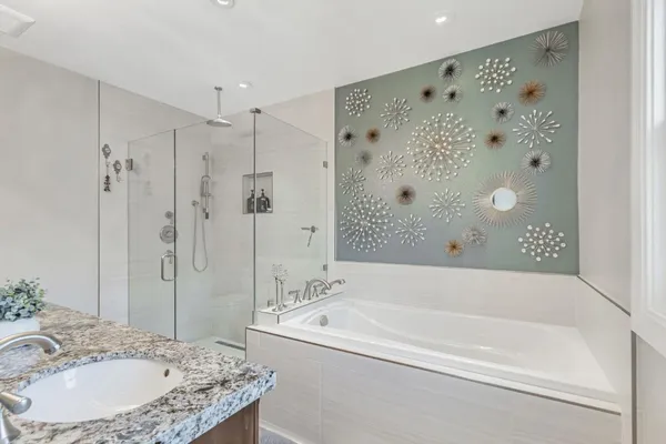 a bathroom with a granite countertop tub sink and mirror