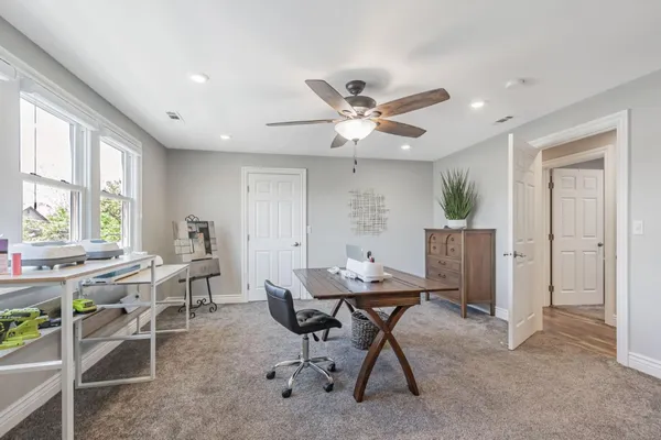 a view of a workspace with furniture and a window