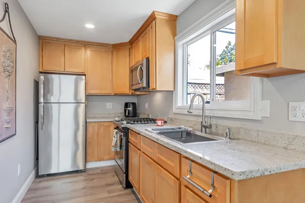 a kitchen with stainless steel appliances granite countertop a refrigerator and a sink