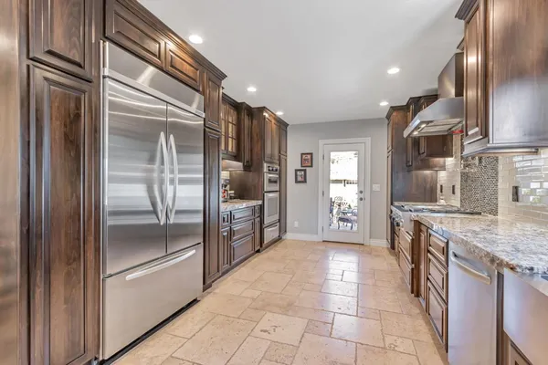 a kitchen with granite countertop a refrigerator and a sink