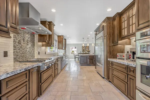 a large kitchen with stainless steel appliances lots of counter space and a sink