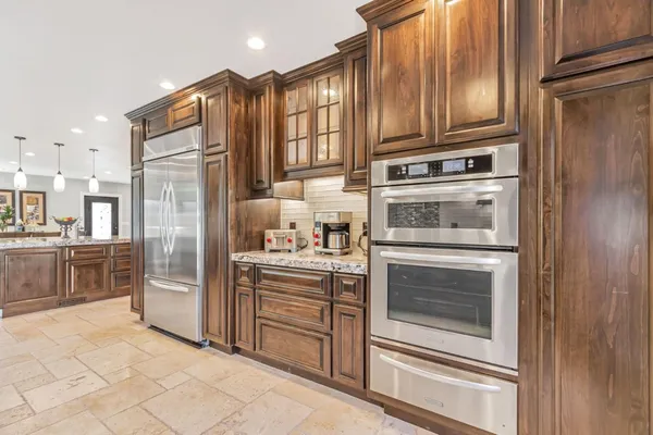 a kitchen with stainless steel appliances granite countertop a refrigerator stove and cabinets