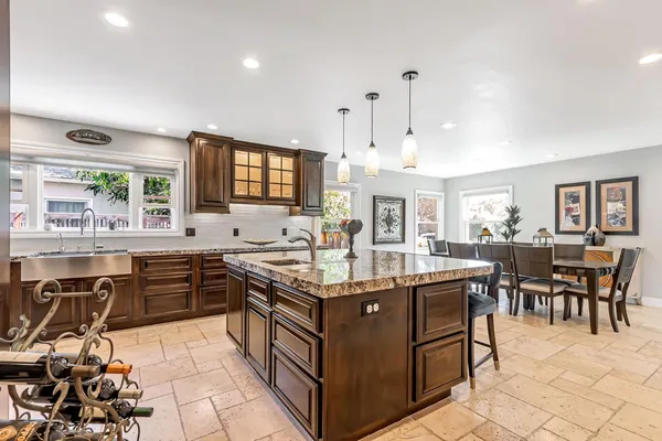 a kitchen with granite countertop a sink a counter top space appliances and dining room