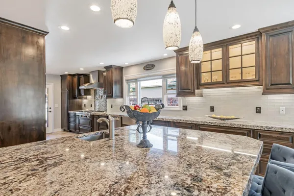 a kitchen with stainless steel appliances granite countertop a sink refrigerator and cabinets