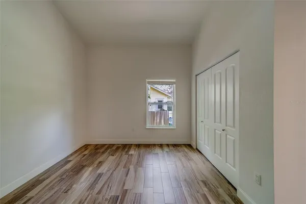 a view of a room with wooden floor and kitchen view