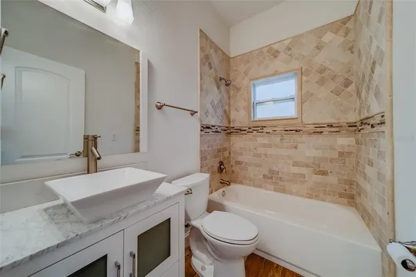a large kitchen with stainless steel appliances a large counter top and wooden floors