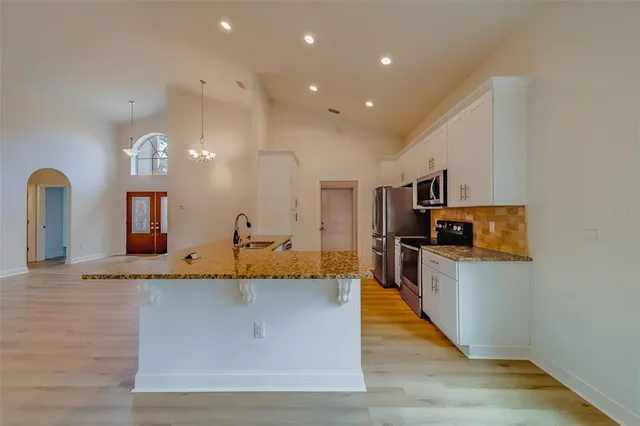 a spacious bathroom with a granite countertop sink and a mirror