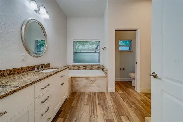 an aerial view of residential houses with outdoor space and trees all around