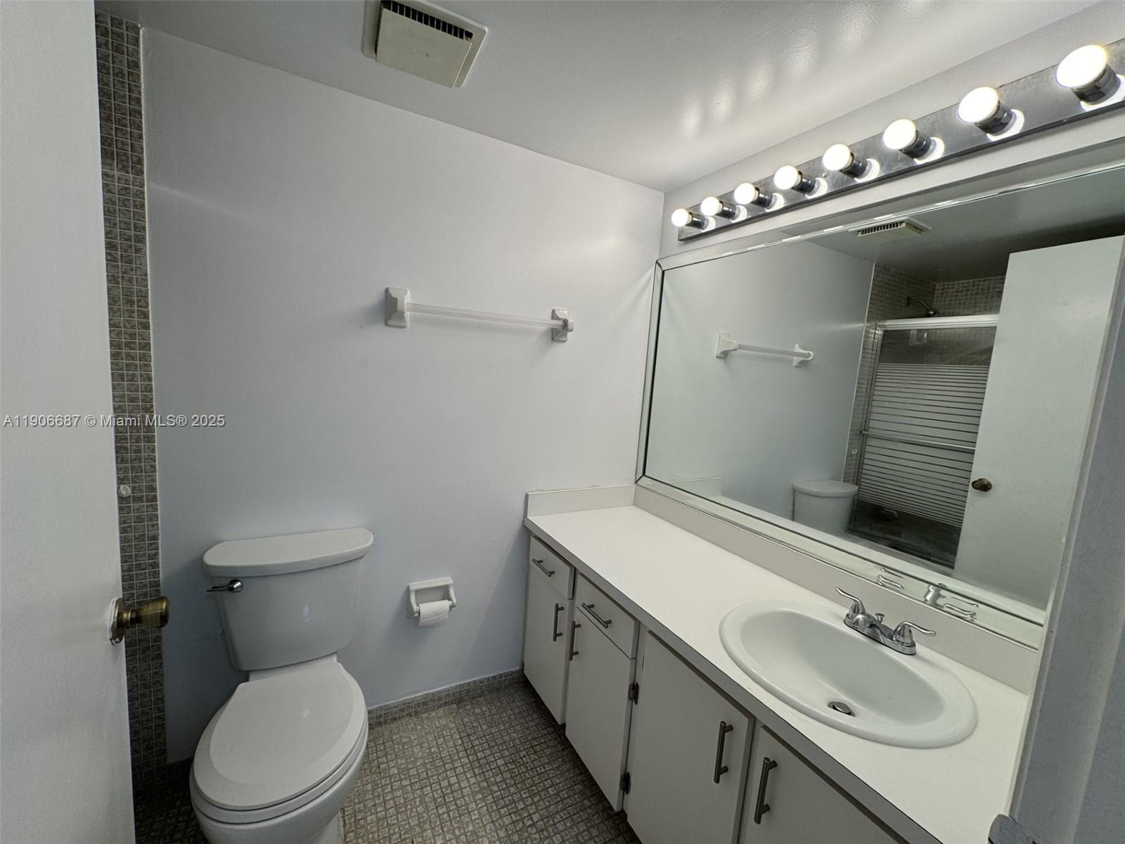 5800 Southwest 127th Avenue, Unit 2307 Miami, FL 33183 - Photo 13 of 23 a bathroom with a toilet sink and mirror