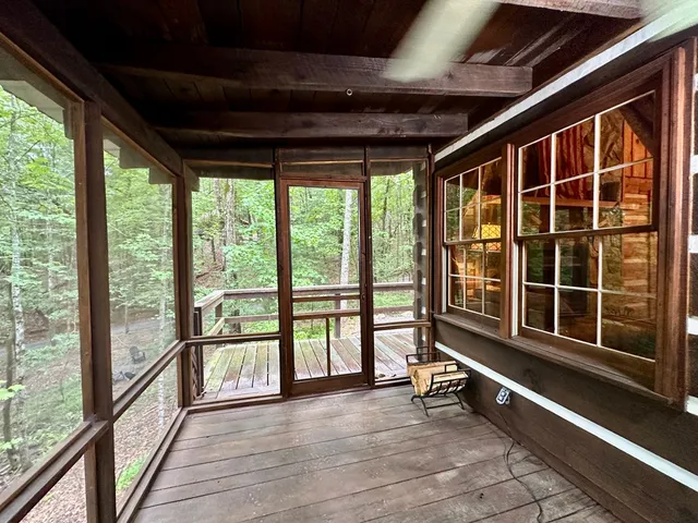 a view of an empty room with wooden floor and windows