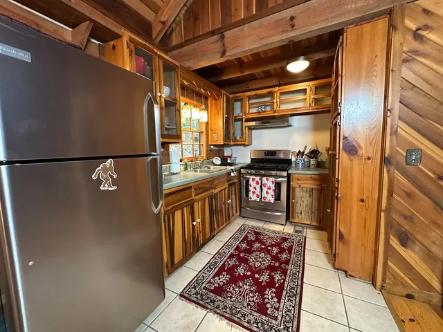 a kitchen with stainless steel appliances granite countertop a refrigerator a stove a sink and dishwasher