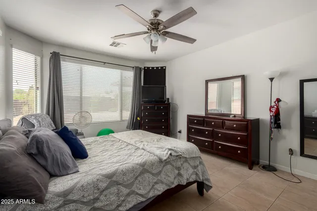 a bedroom with a bed and a mirror on dresser