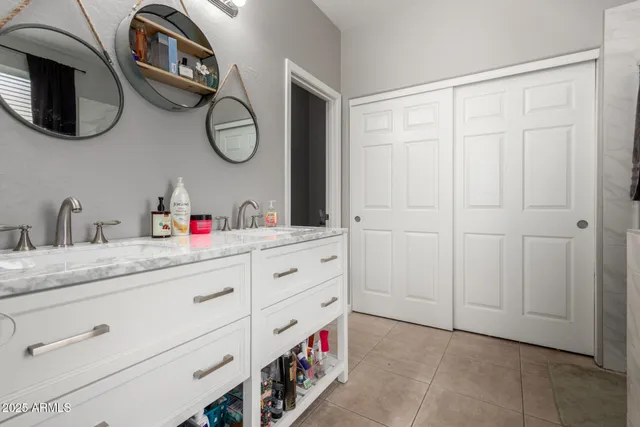 a bathroom with a granite countertop double vanity sink and a mirror