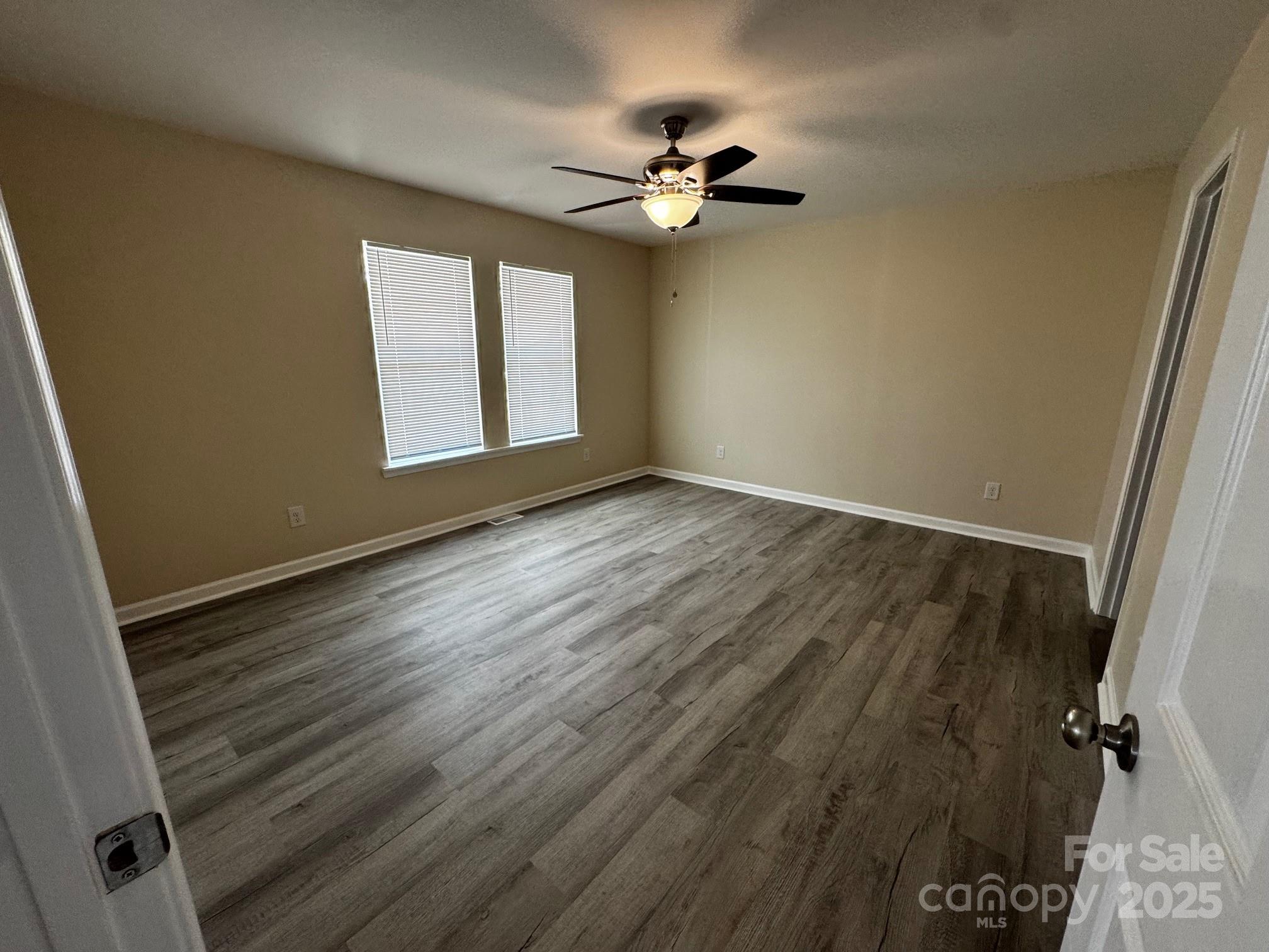 194 Providence Mill Road Maiden, NC 28650 - Photo 4 of 15 an empty room with wooden floor fan and windows