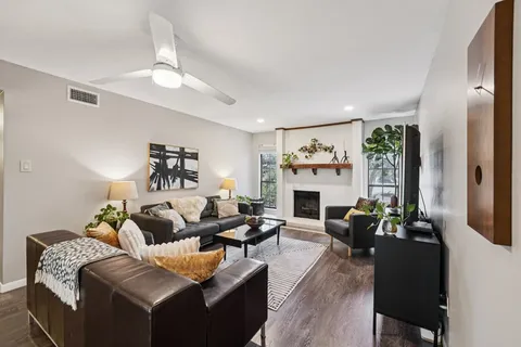 a living room with furniture a fireplace and a chandelier