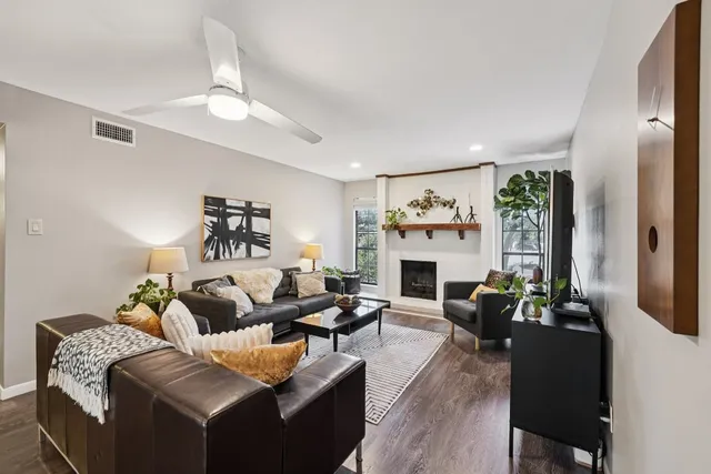 a living room with furniture a fireplace and a chandelier