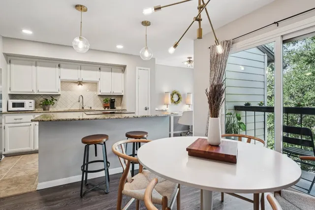 a kitchen with kitchen island a dining table and chairs