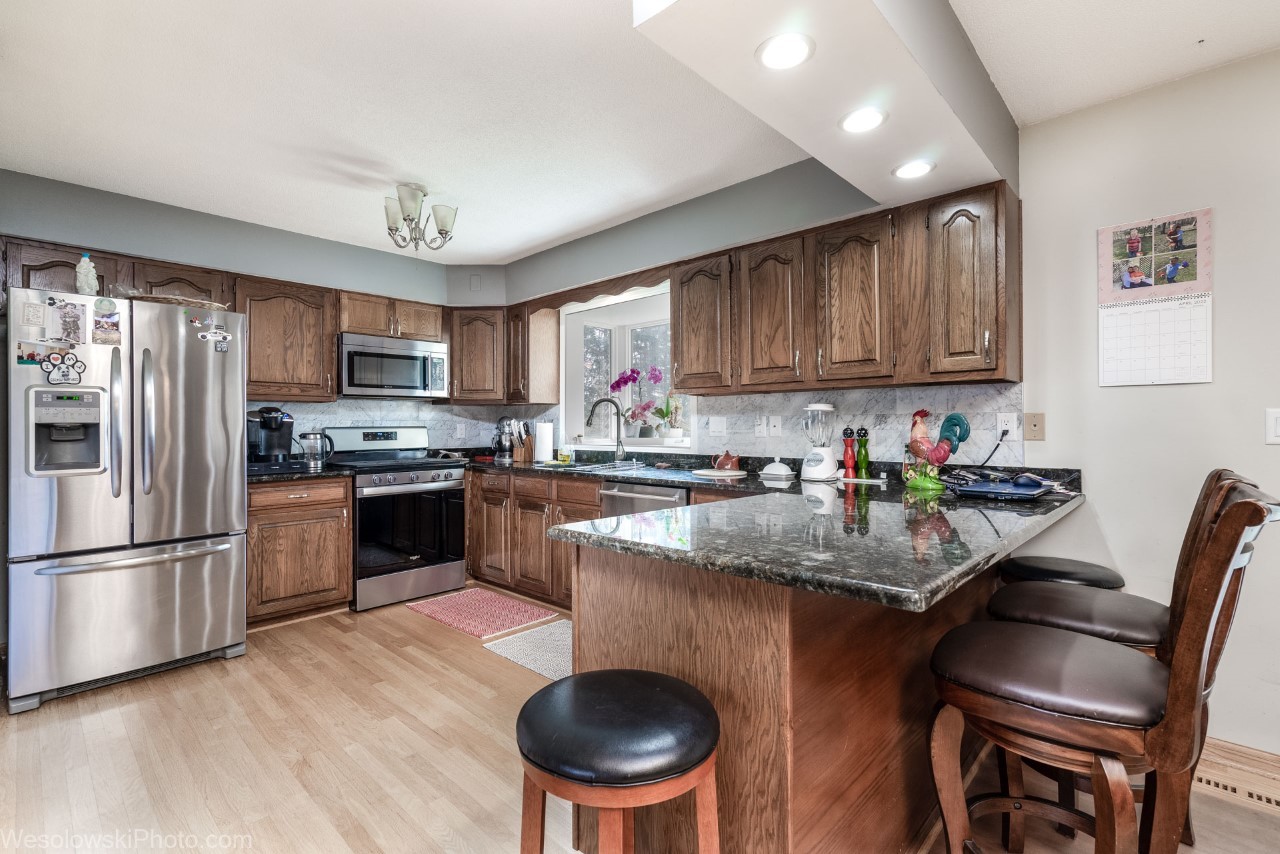 18525 Ridge Lane Marengo, IL 60152 - Photo 11 of 35 a kitchen with a refrigerator a stove a sink dishwasher with a dining table and chairs