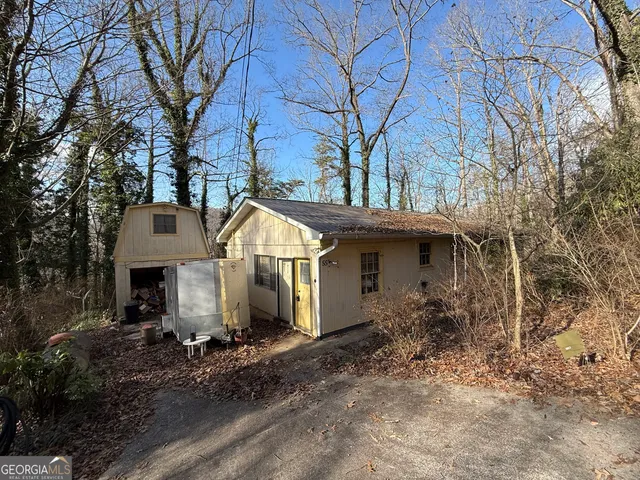 a front view of house with yard and trees around