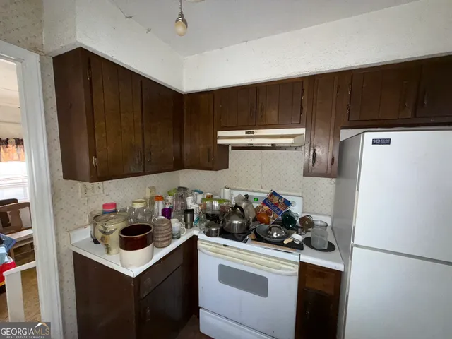 a kitchen with a refrigerator and a stove top oven